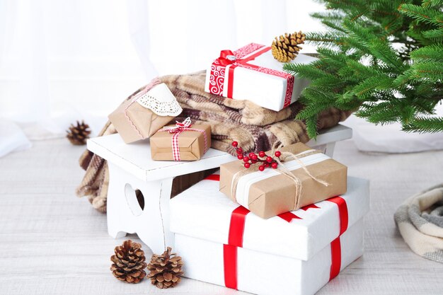 Christmas presents  near Christmas tree on wooden background