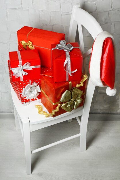 Christmas presents on white chair on brick wall