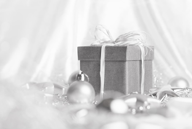 Christmas presents with silver ribbon on white wooden background