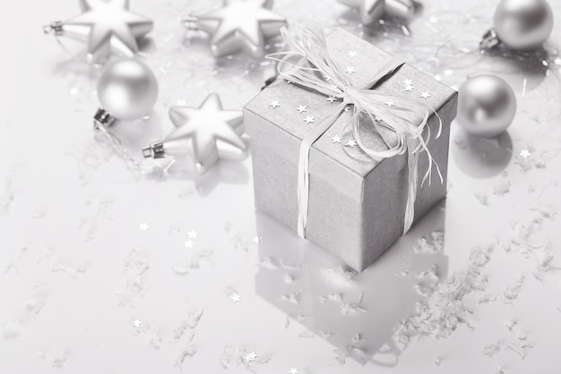 christmas presents with silver ribbon on white wooden background
