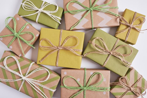 Christmas presents wrapped in craft paper on white background. Top view, flat lay.