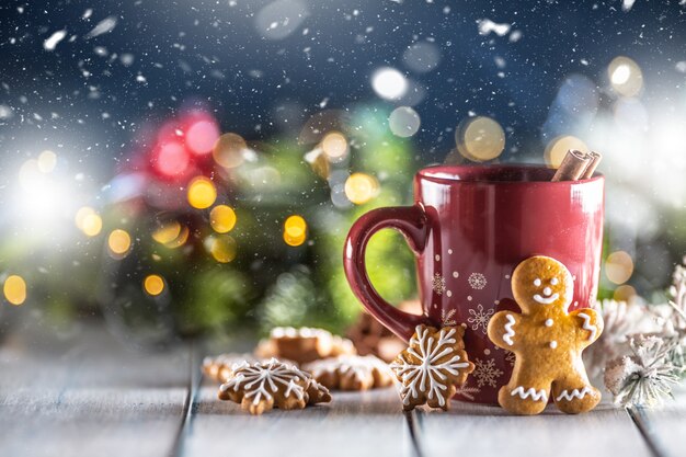 Christmas punch in a red cup with gingerbread cinnamon and holiday decorations.