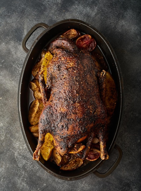 A Christmas recipe for roasted goose stuffed with baked apples on a gray background