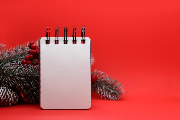 Christmas red background with a clean notepad fir branches todo list for christmas