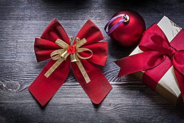 Christmas red ball bow present box on wooden board