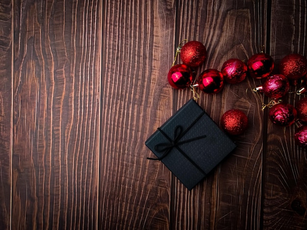 나무 테이블에 있는 크리스마스 빨간 공과 선물 상자 휴일 크리스마스 배경 텍스트 또는 디자인을 위한 공간 복사 위에서 보기