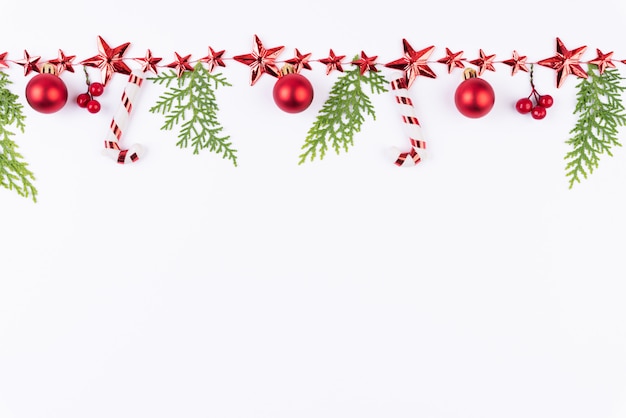 クリスマスの赤いボールは、緑のトウヒの枝と白い背景に星。