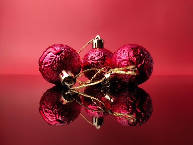 赤い背景に反射したクリスマスの赤いボール休日のクリスマスの背景