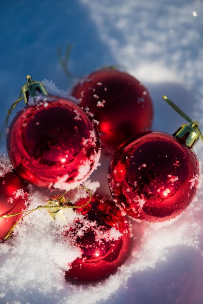 christmas red balls with long shadows  in fresh snow on beautiful sunny winter day