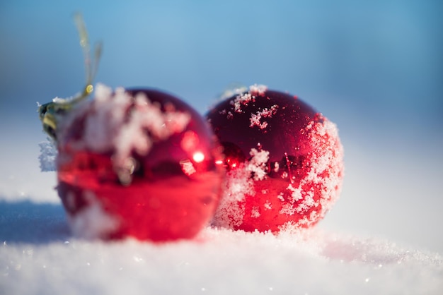 christmas red balls with long shadows  in fresh snow on beautiful sunny winter day