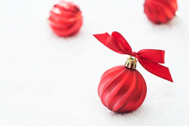 Photo christmas red baubles isolated on snow. winter greeting card.