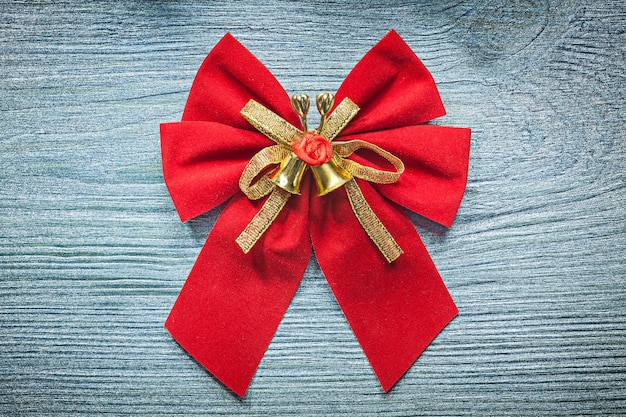 Photo christmas red bow with bell on wooden board celebrations concept