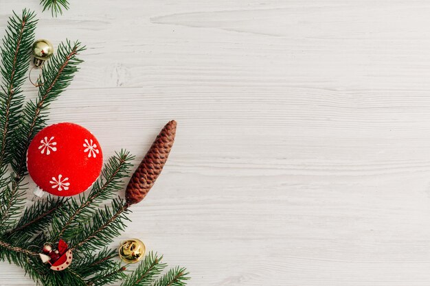 コピースペースのテキストと白い木製のテーブルの上のクリスマスの赤い装飾