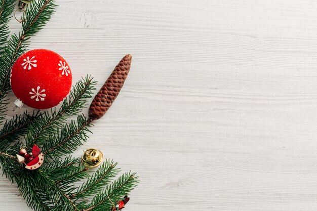 コピースペースのテキストと白い木製のテーブルの上のクリスマスの赤い装飾