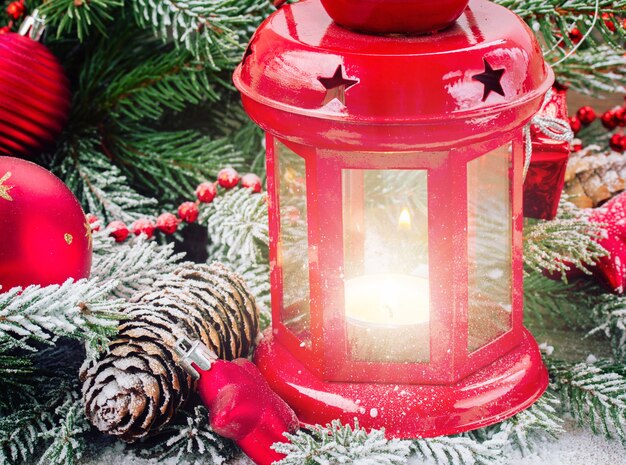 Photo christmas red glowing lantern close up  with evergreen tree and snow