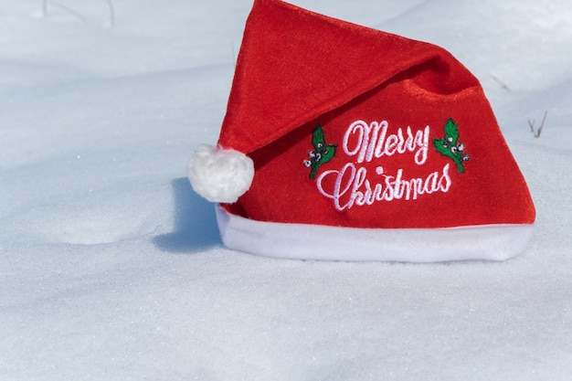 Christmas red hat on the white snow holiday celebration concept