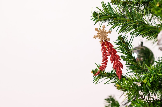 Foto decorazione lucida rossa di natale situata appesa su un ramo di un albero di natale