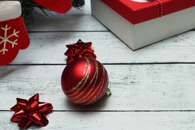 Foto sfondo di natale rosso e argento con fiocchi di palle calzino di natale e regali su un tavolo di legno con spazio per la copia