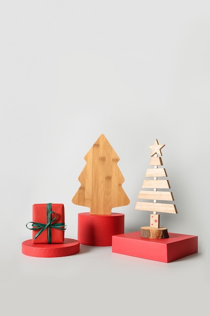 Фото Рождественские красные подставки с подарками и декоративной деревянной креативной елкой