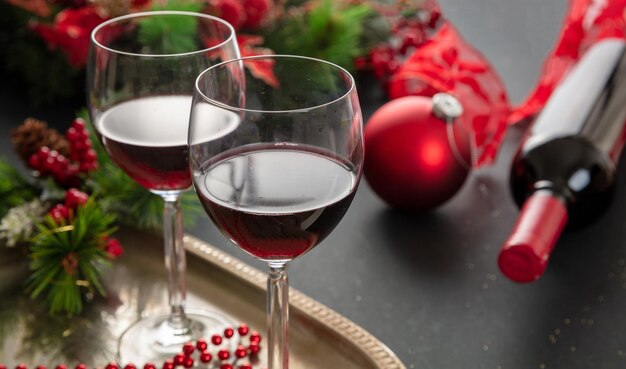 テーブルのクローズ アップ ビューでクリスマスの赤ワインのグラスとクリスマスの装飾