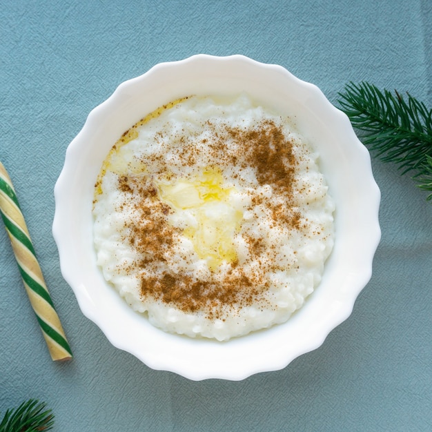 Porridge di riso natalizio con burro e cannella su sfondo blu in tessuto, vista dall'alto