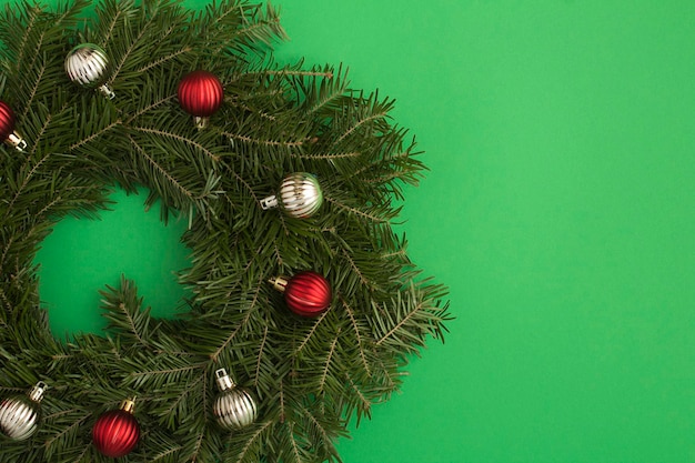 Christmas ring or wreath with colored balls on the green background Copy space Top view