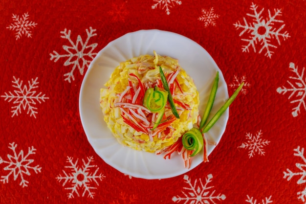 Christmas salad made from crab meat, eggs and corn in a white plate. Seafood dish.