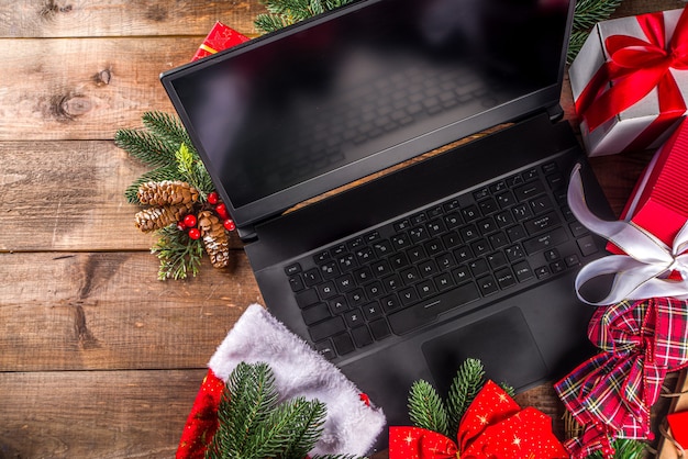 Concetto di vendita di natale. sfondo nero venerdì, verde o cyber monday con laptop, tablet, decorazioni natalizie e scatole regalo,