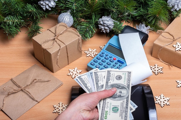 Photo christmas sale the hand holds cash to pay for gifts for the holidays buying new year's gifts cash register receipt