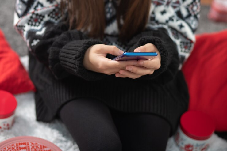 Photo christmas sales. girl chooses gifts on a mobile phone