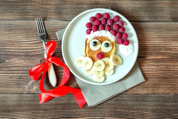 사진 크리스마스 산타클로스 얼굴 모양의 팬케이크 신선한 라즈베리 베리 바나나 어린이용 접시 어린이 아침 식사 크리스마스 음식 디저트 새해 클로즈업