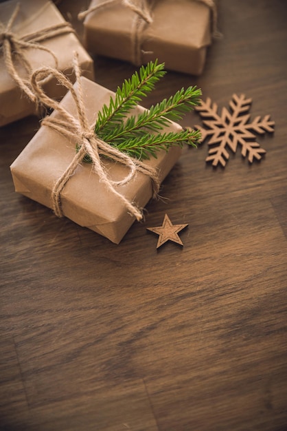 Photo christmas season gift boxes with spruce branch on the rustic table