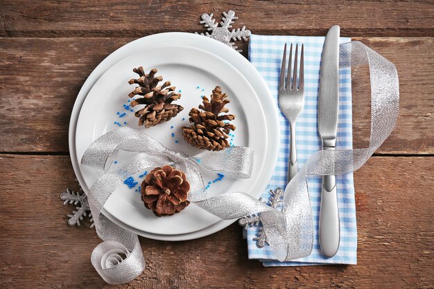 Photo christmas serving cutlery with napkin and plate on a wooden background