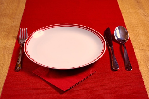 Christmas serving cutlery with napkin and plate on a wooden background.