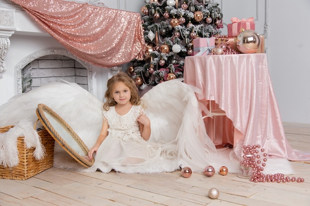 Christmas shooting of a cute little girl in the studio with wings