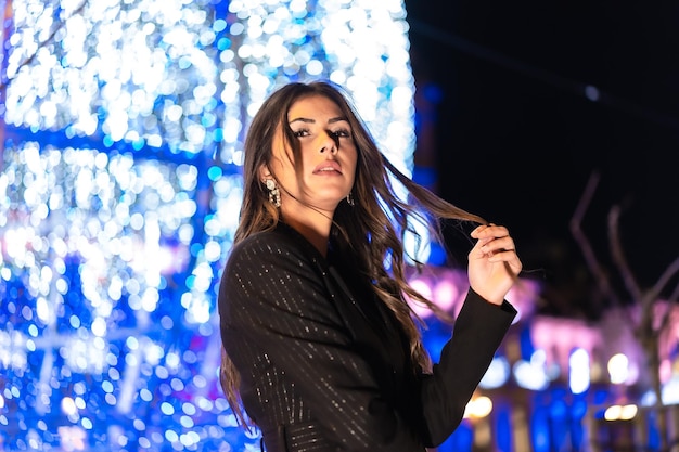 Christmas shooting Young Caucasian brunette enjoying the city lights at Christmas