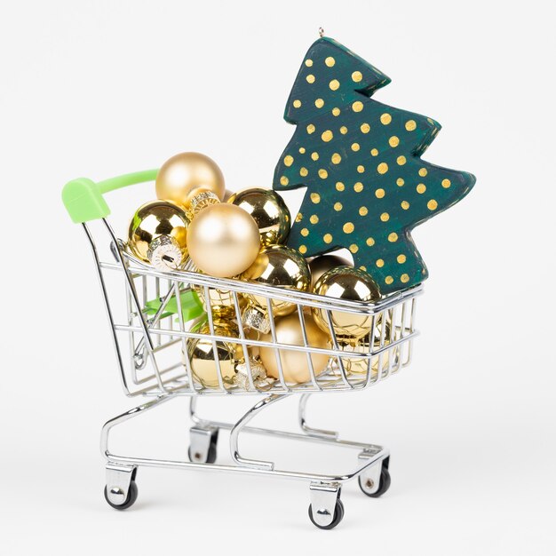 Christmas shopping concept. Shopping mini trolley with Christmas balls and Christmas tree isolated on white. . High quality photo