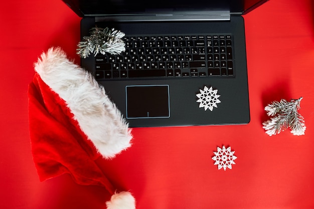 Concetto di shopping online di natale, computer portatile con schermo verde posizionato sul tavolo con regali decorati di natale, vista dall'alto della scrivania con computer portatile, scatole regalo