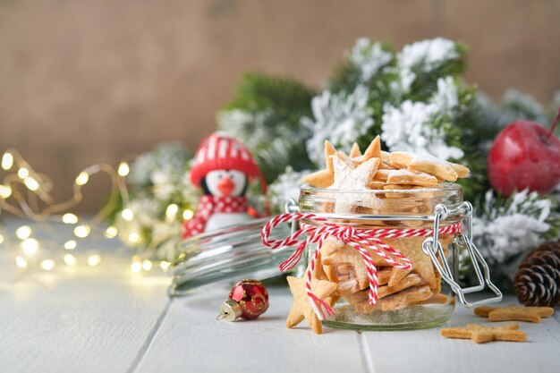 Christmas shortbread cookies or gingerbread stars with red\
ribbon festive decoration fir treeballs and light garland\
traditional german cookies christmas celebration traditions family\
culinary