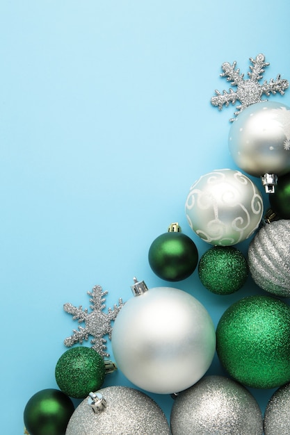 Christmas silver baubles on blue background with copy space. Vertical photo.