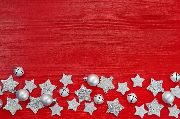 Christmas silver decoration on red background. Flat lay. Top view, copyspace. Red Christmas background with stars and bells. 