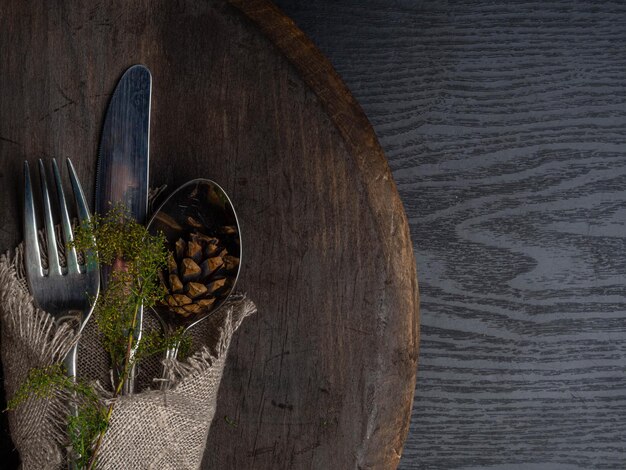 Christmas silverware at dark wooden table with cone Top view copy space