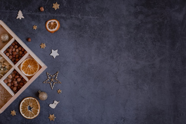 Christmas small accessories and a wooden box with cells on a dark background. Space for text.