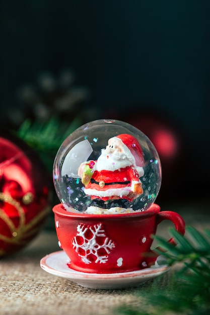 Рождественский снежный шар на темном столе