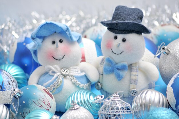 Photo christmas snowman and snow maiden surrounded by new year's toys