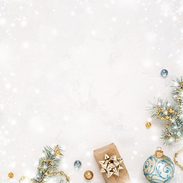 Christmas snowy white background, gift, twigs and gold blue decorations.