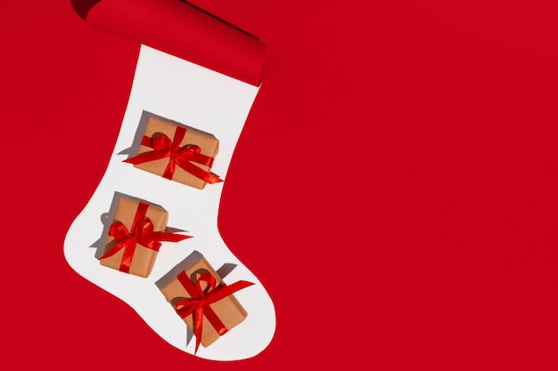 Christmas sock with gifts on white and red background Space for text Mockup