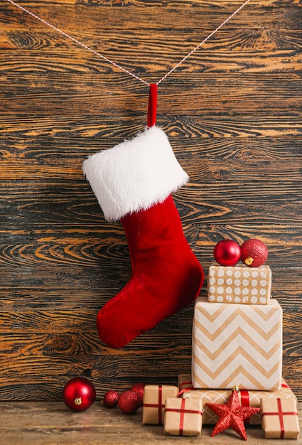 Christmas sock with gifts on wooden space