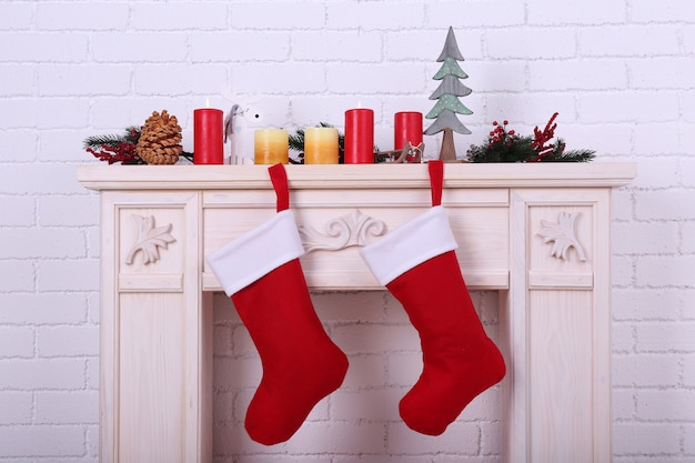 Photo christmas socks hanging on fireplace in room