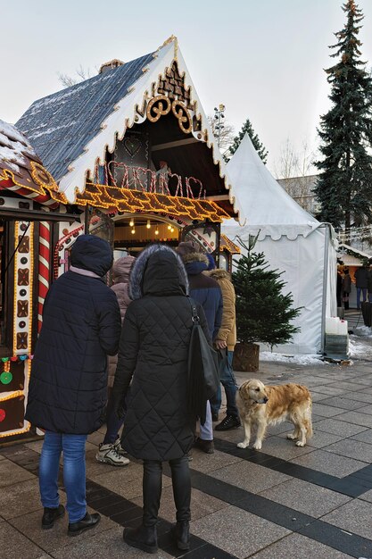 Рождественский сувенирный магазин и посетители рождественского рынка на Соборной площади в Вильнюсе.